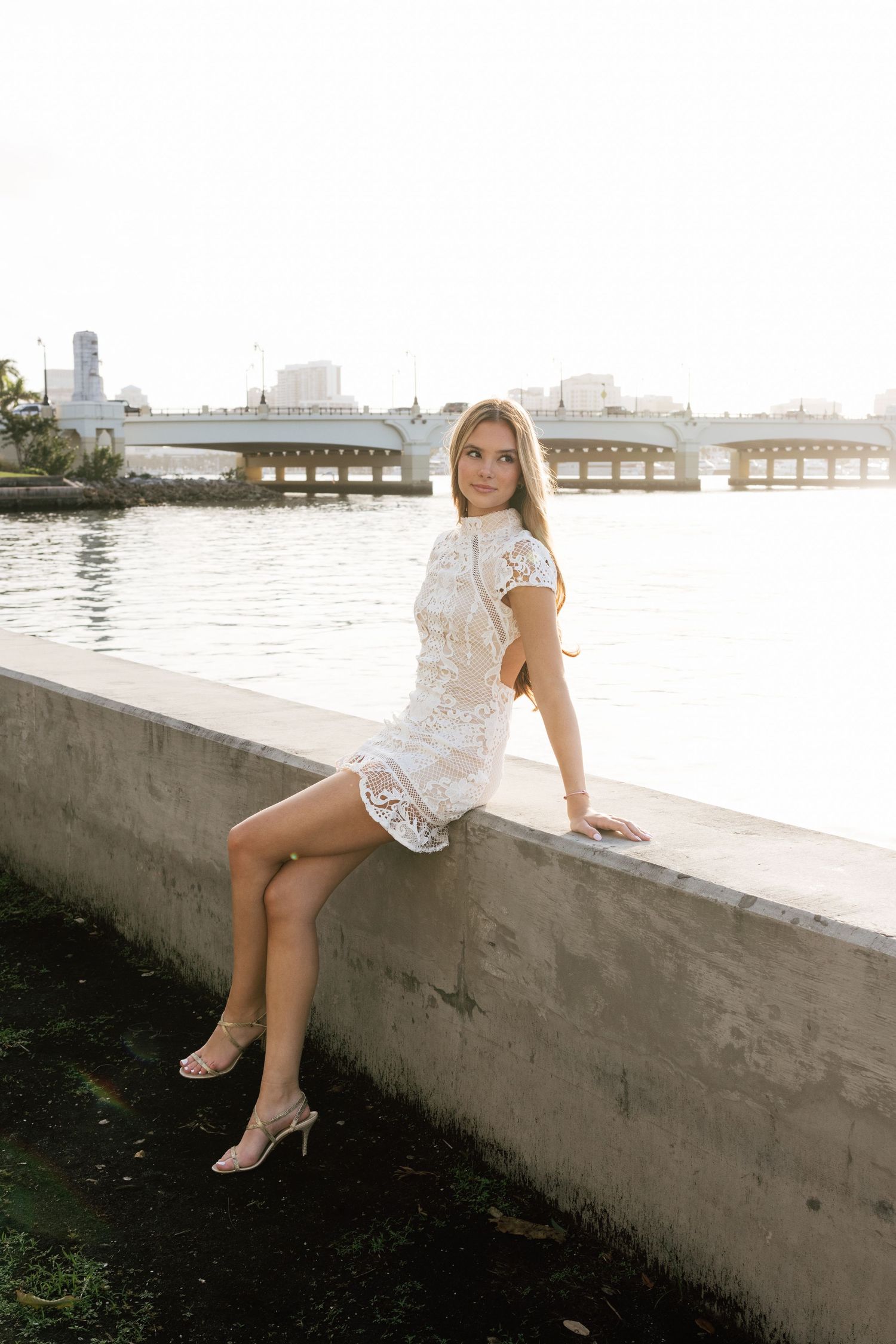 Waterfront photoshoot at sunset with city skyline in background.