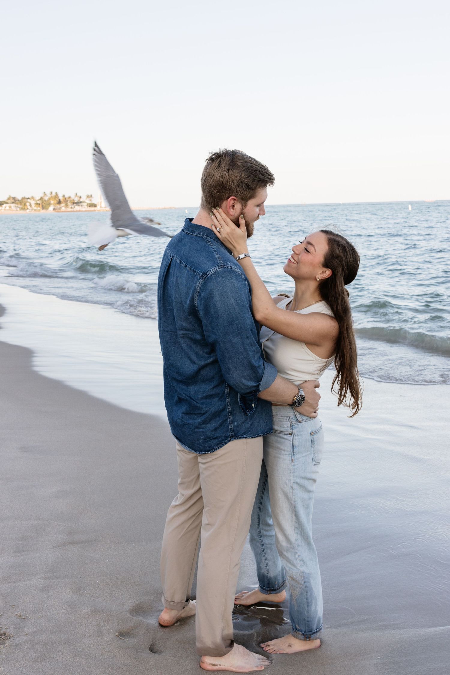A couple shares an intimate dance moment at the water's edge.