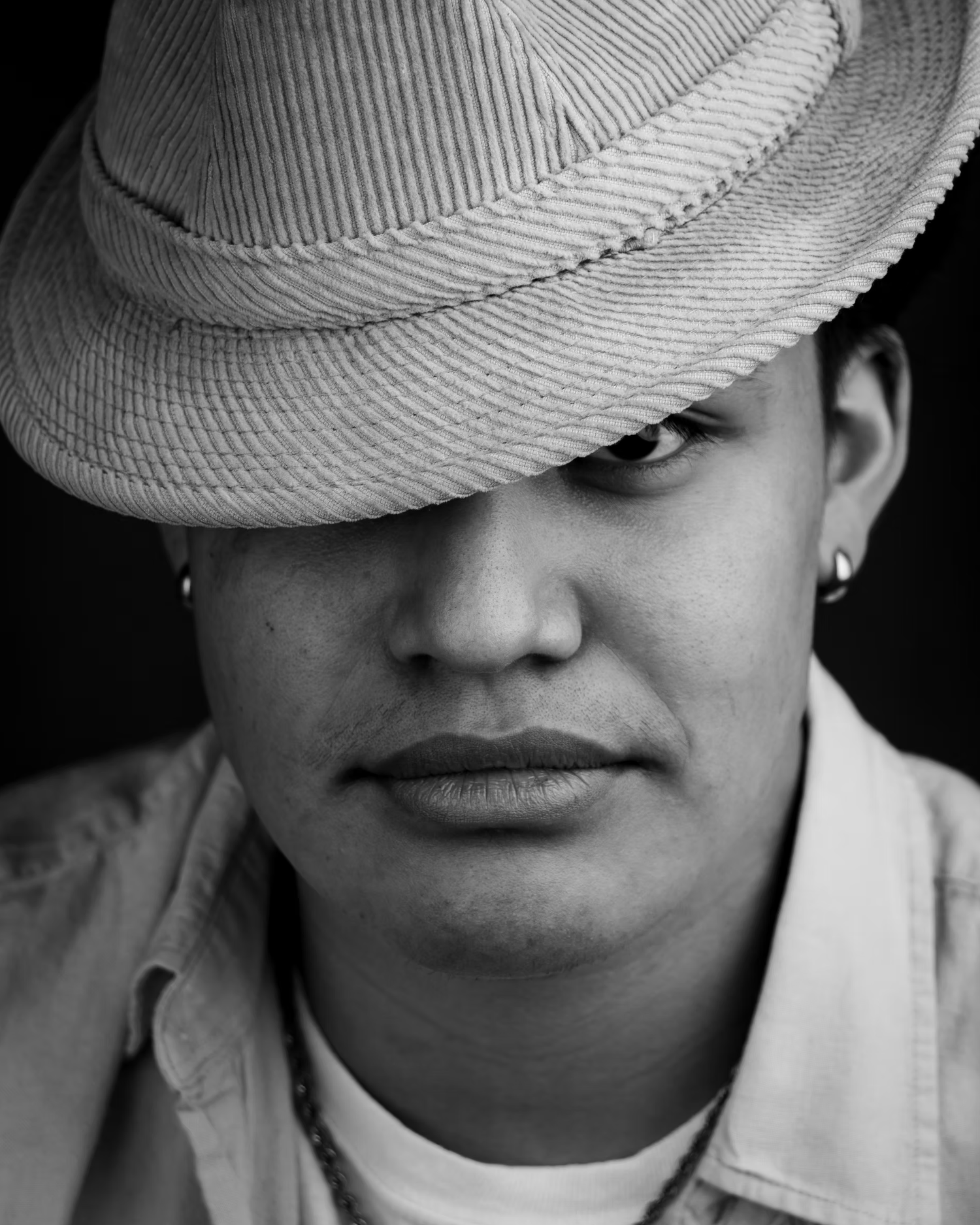 Close-up black and white portrait featuring striped fedora hat.