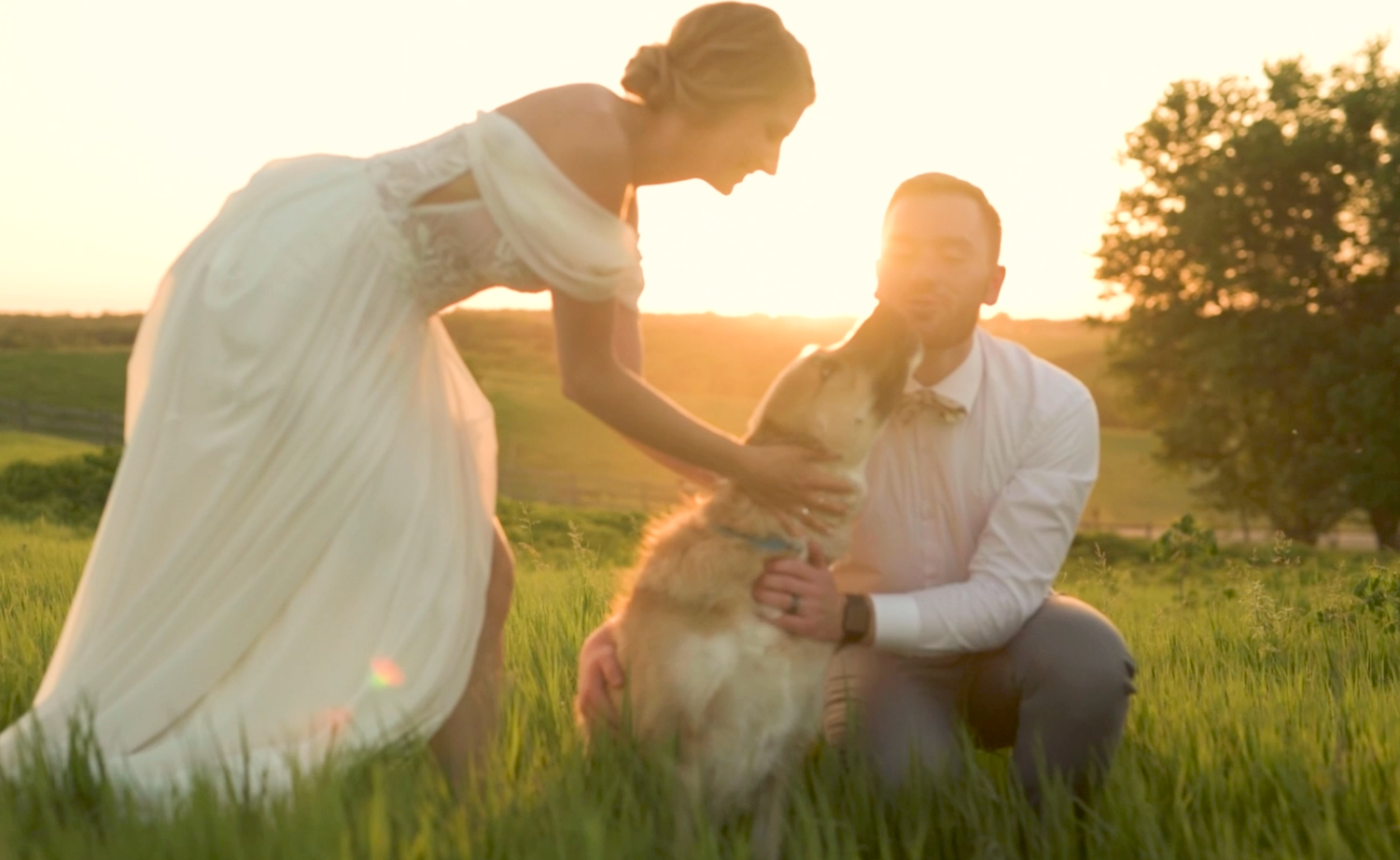 Couple sitting together in a grassy meadow at sunset enjoying a romantic moment in nature.