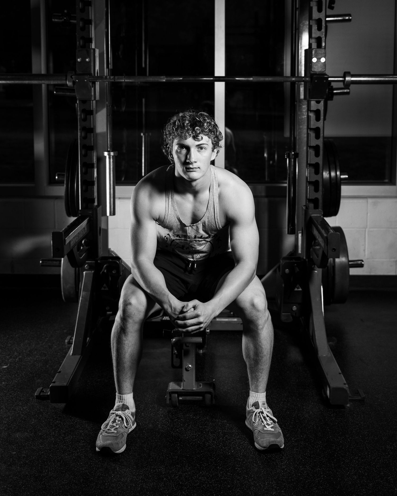 Dramatic black and white photo of athlete working out in weight room.