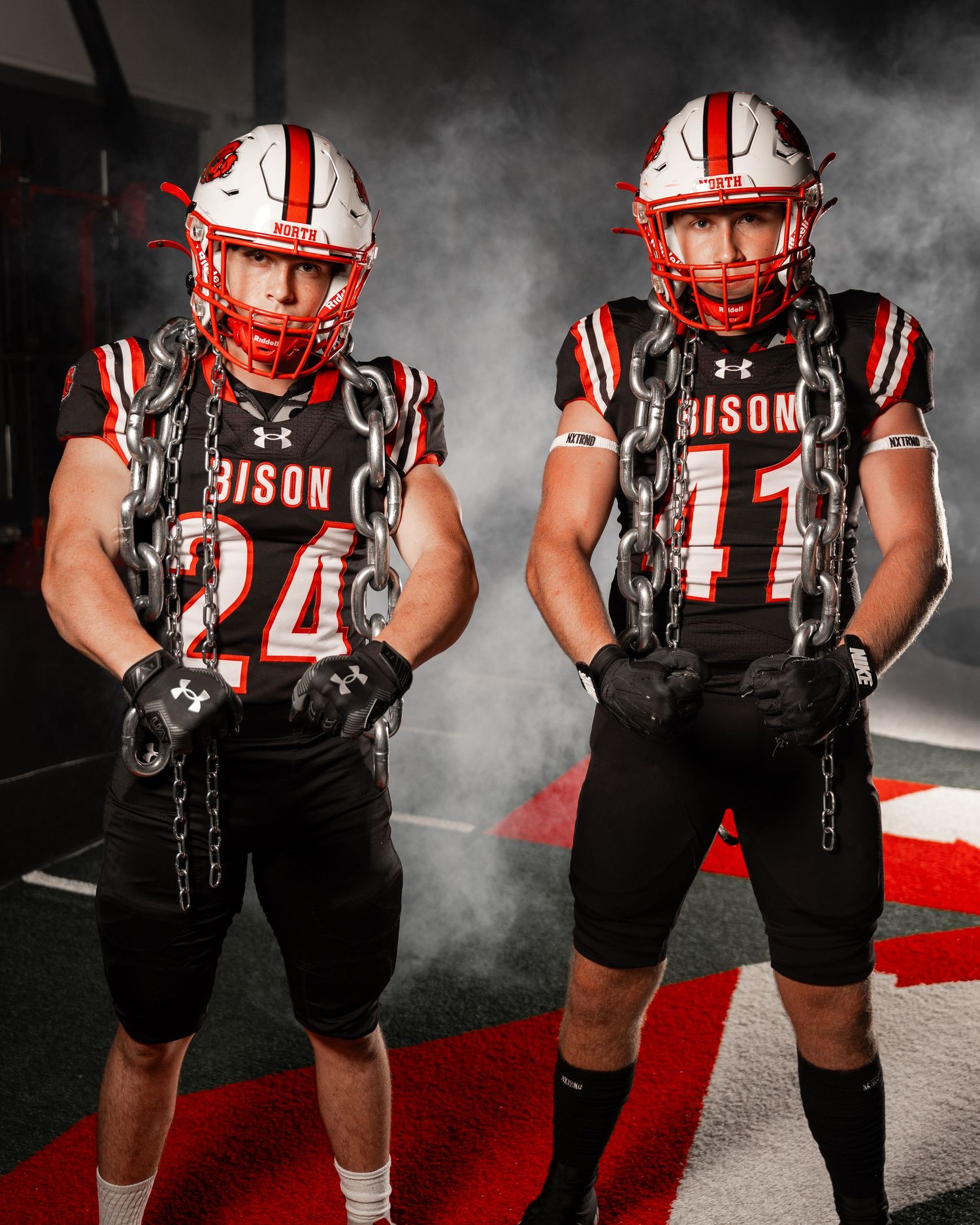 Football players in Bison uniforms posing in atmospheric smoke effect.