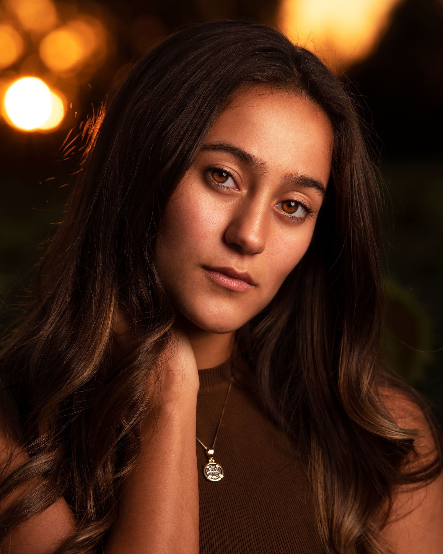 Close-up portrait with warm lighting and soft bokeh effects in the background.