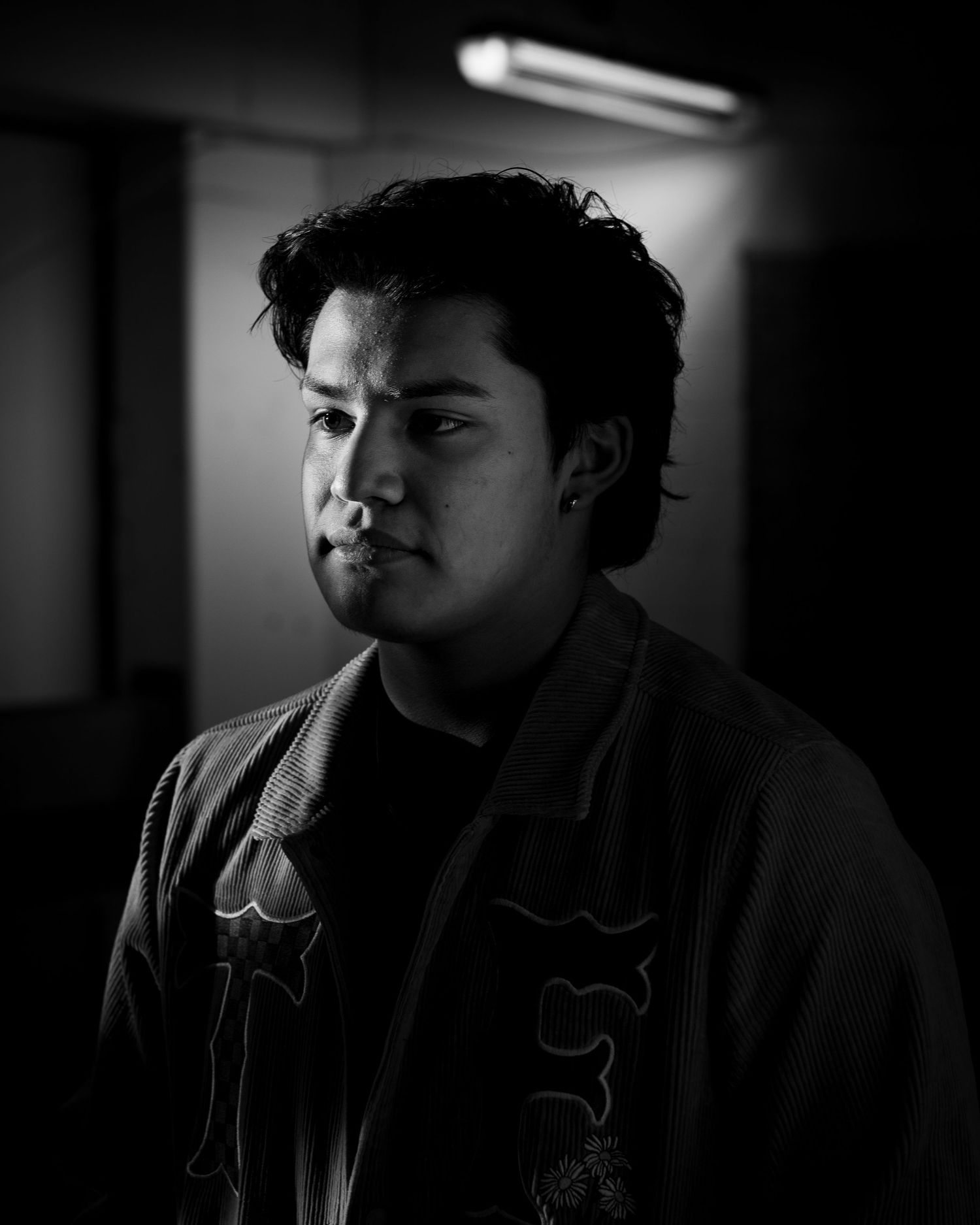 A series of moody black and white portraits showing dramatic side lighting in a dark environment.
