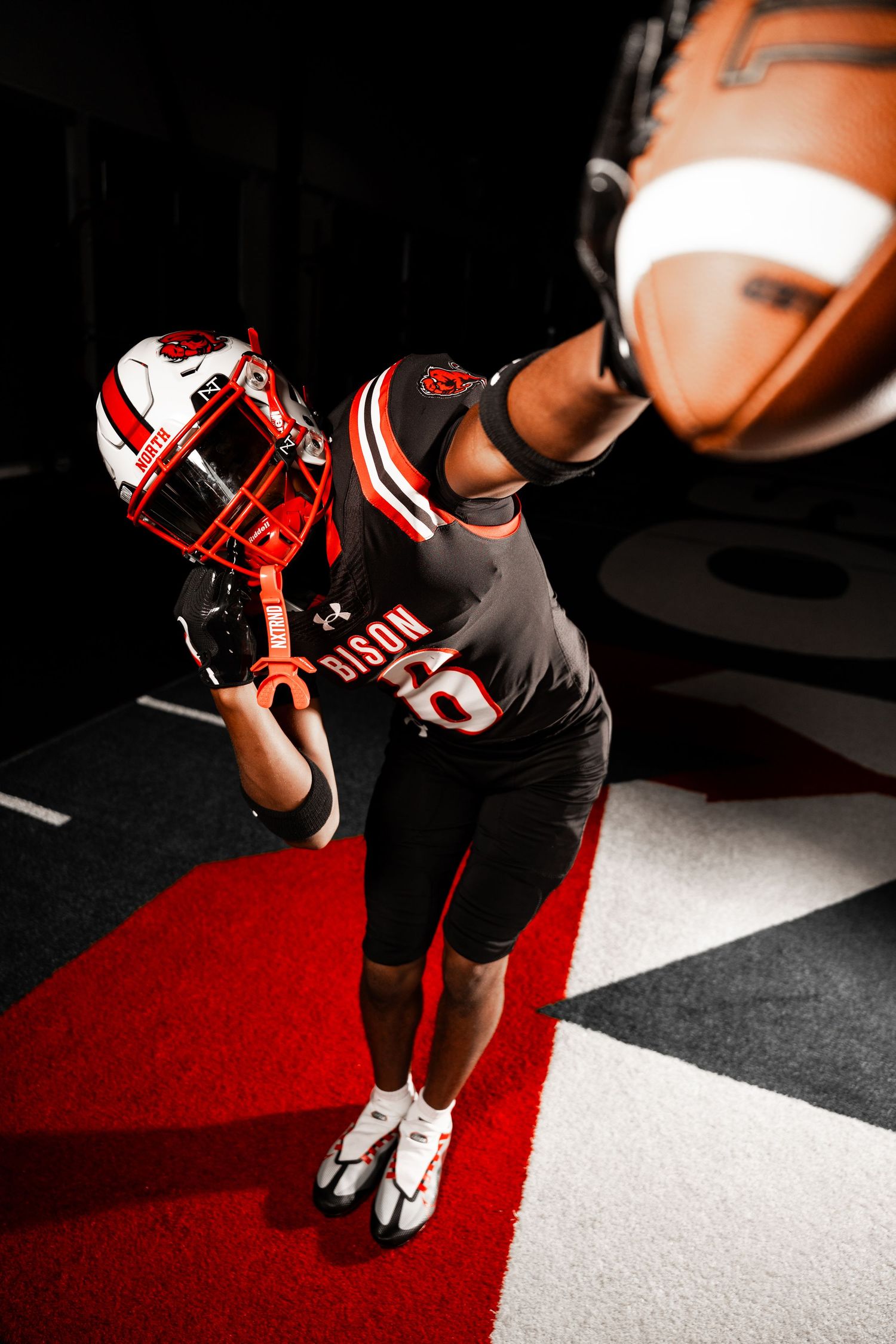 Artistic shot of football equipment and uniforms under dramatic spotlight.