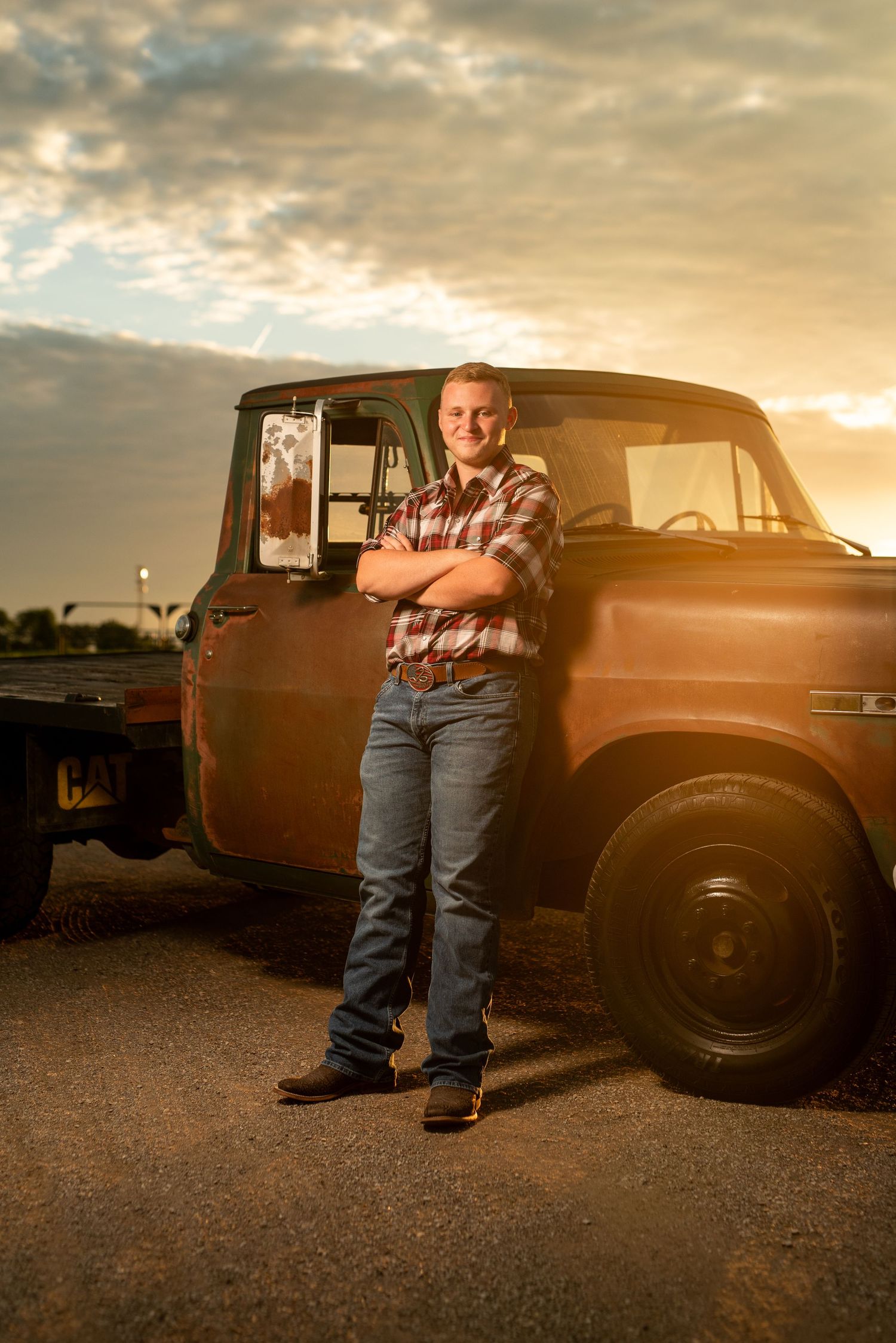 Vintage brown truck photographed during golden sunset on gravel road.