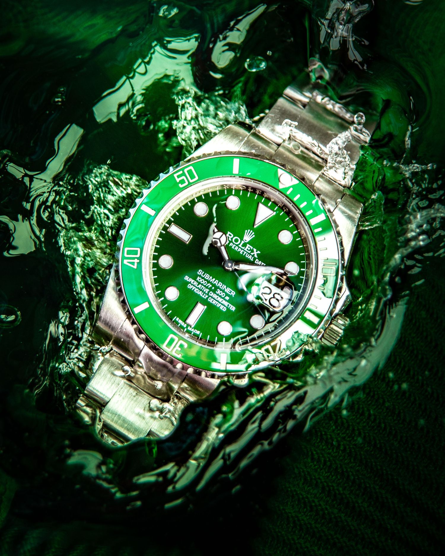 Luxury green dive watches photographed underwater with dramatic lighting effects.