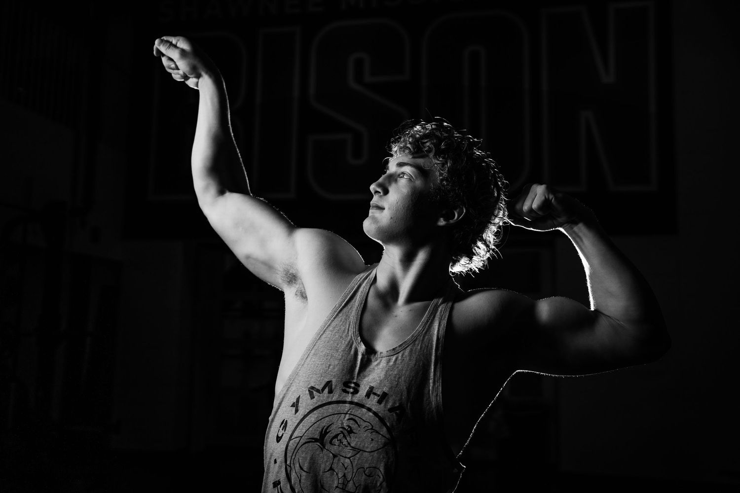 Athlete performing strength training exercises in dark gym setting.