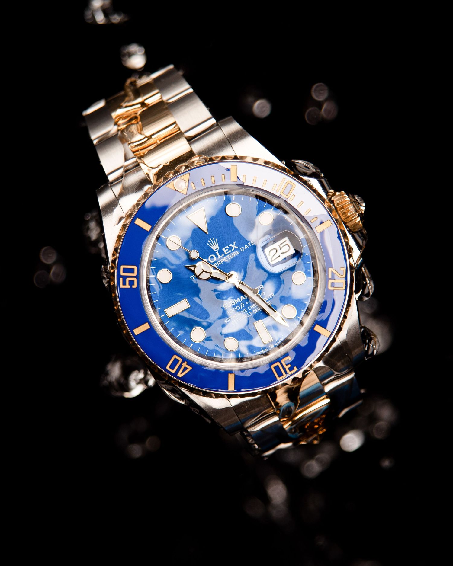 Luxury dive watch with blue dial shown in multiple angles against dark background with bokeh effects.