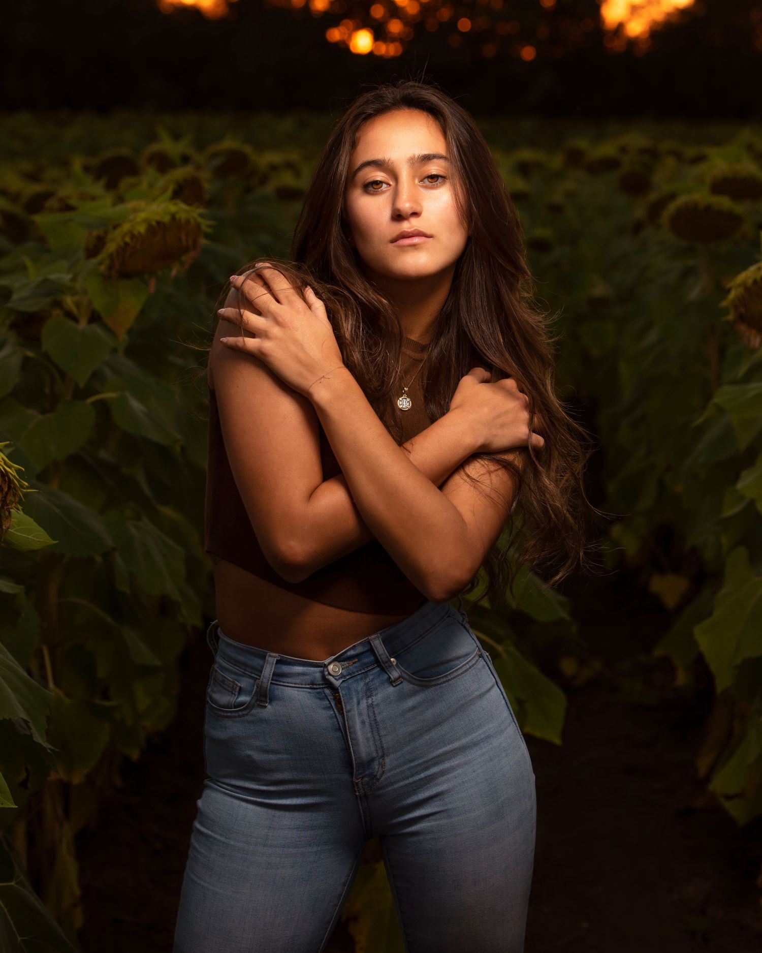Artistic portrait session in nature featuring denim and dramatic lighting at sunset.