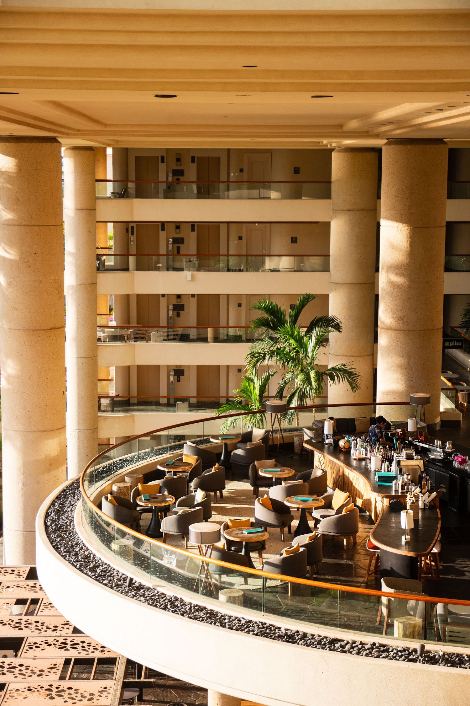 Modern curved hotel lobby with white columns and comfortable seating arrangements.