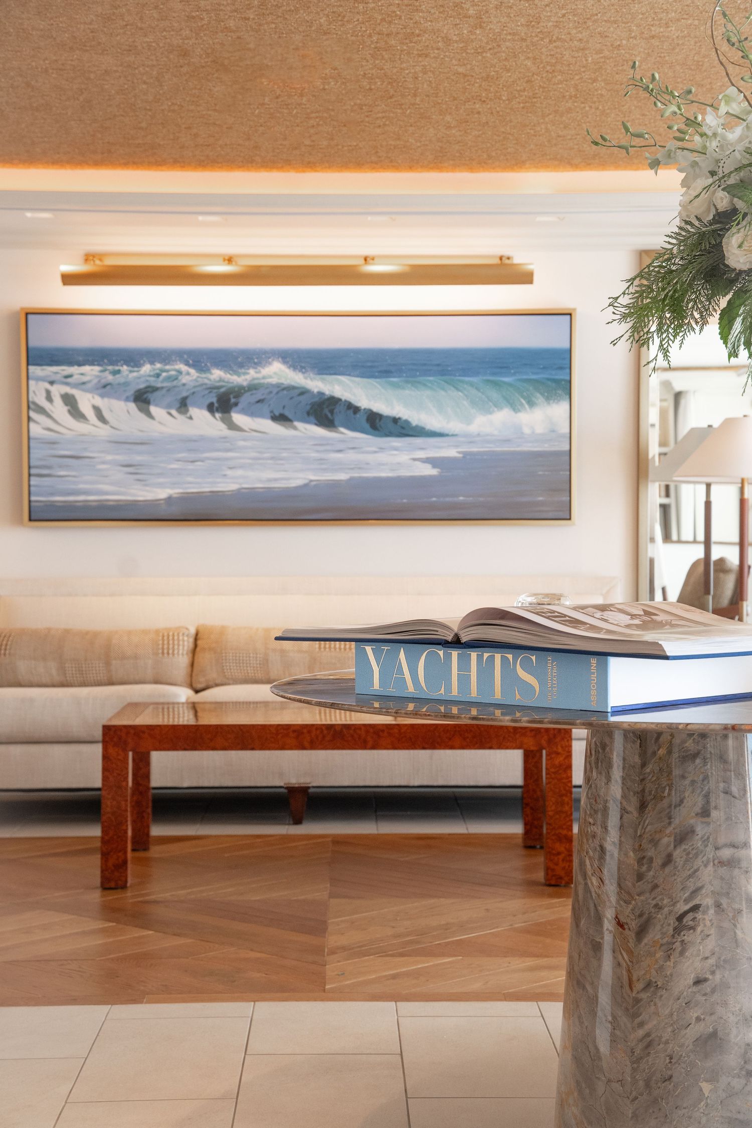 Modern lobby area with wooden benches and large ocean wave photographs on display.