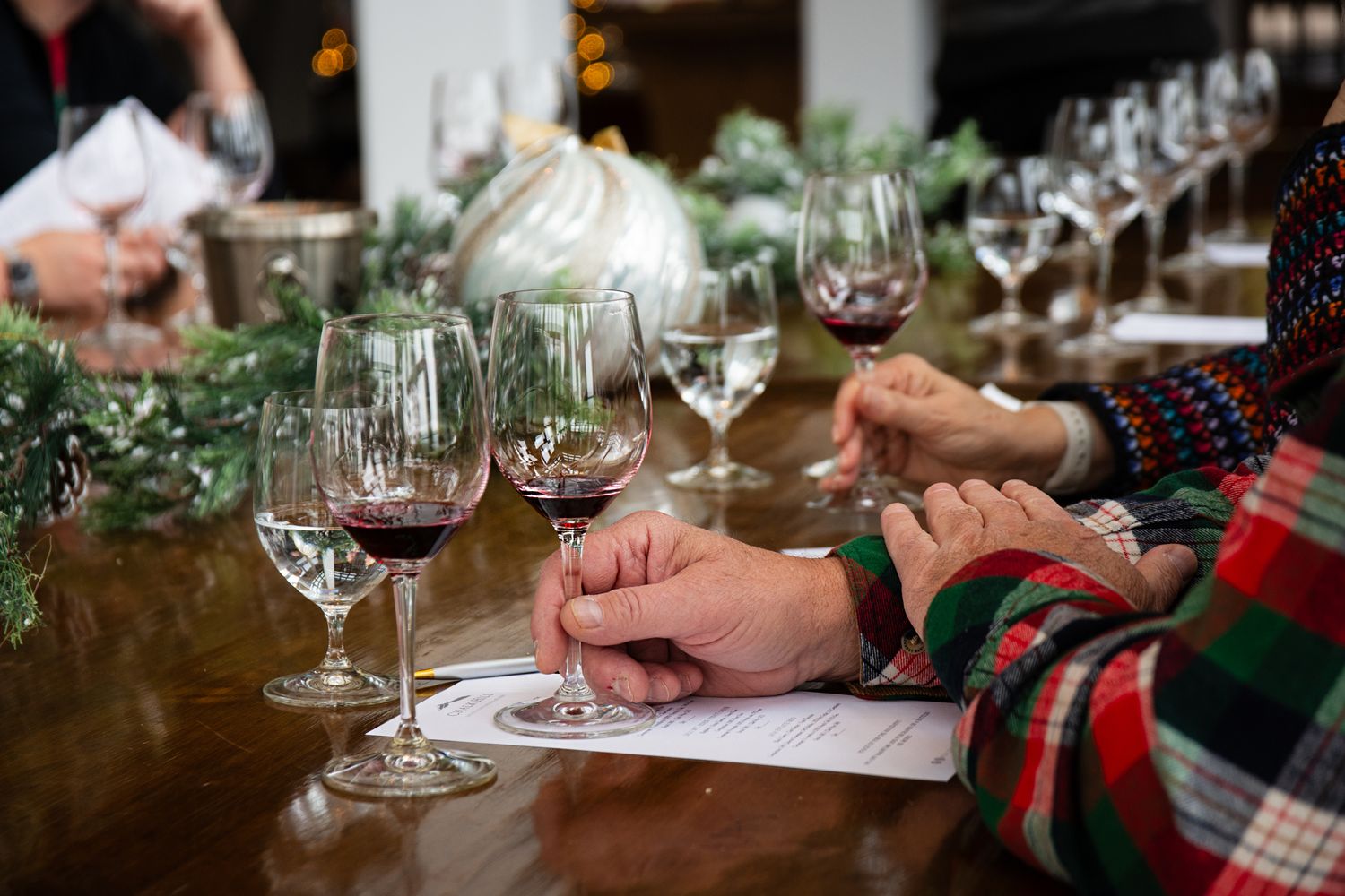 Wine tasting participants taking notes during a holiday wine tasting event.