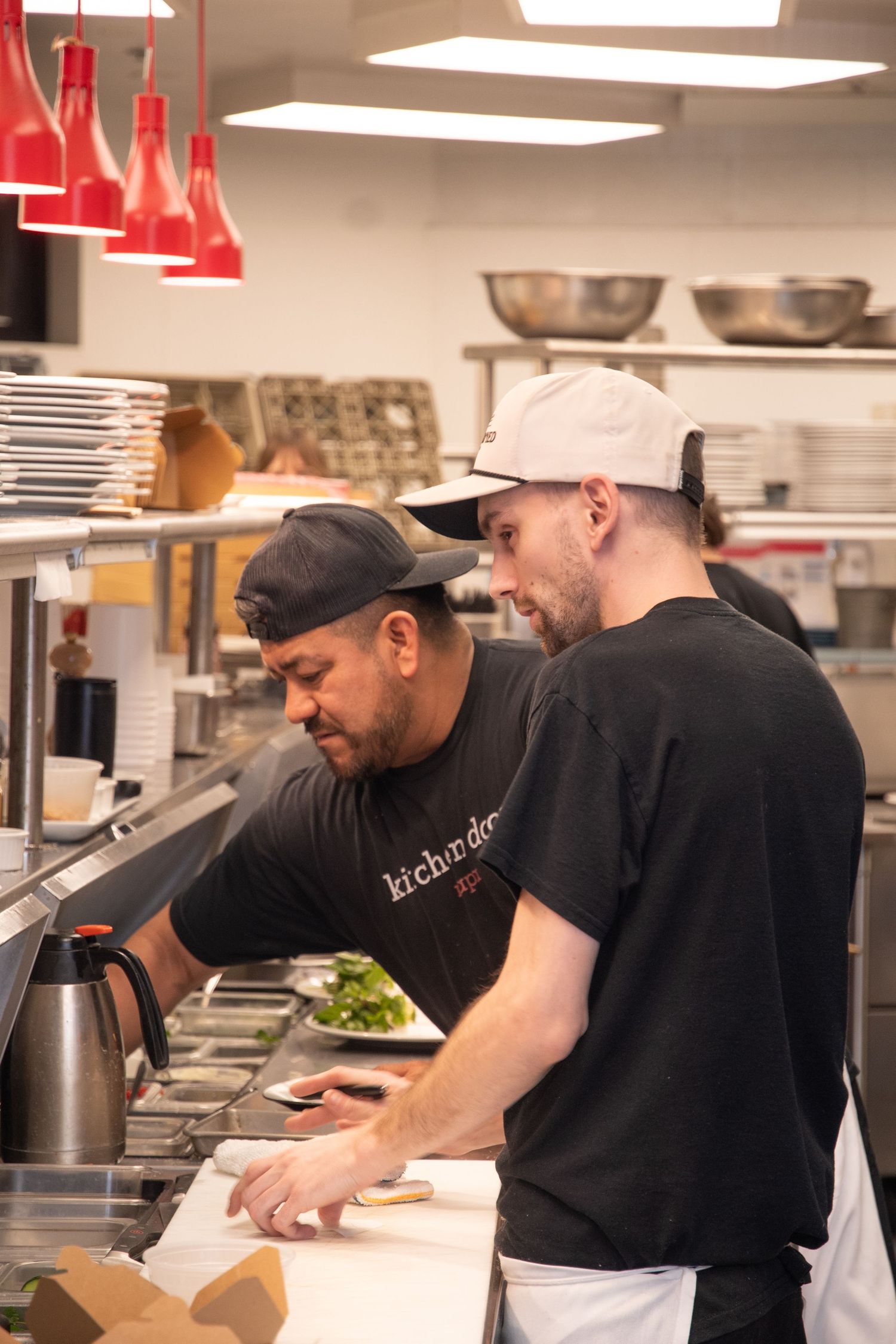Kitchen staff preparing food at a busy restaurant prep station.