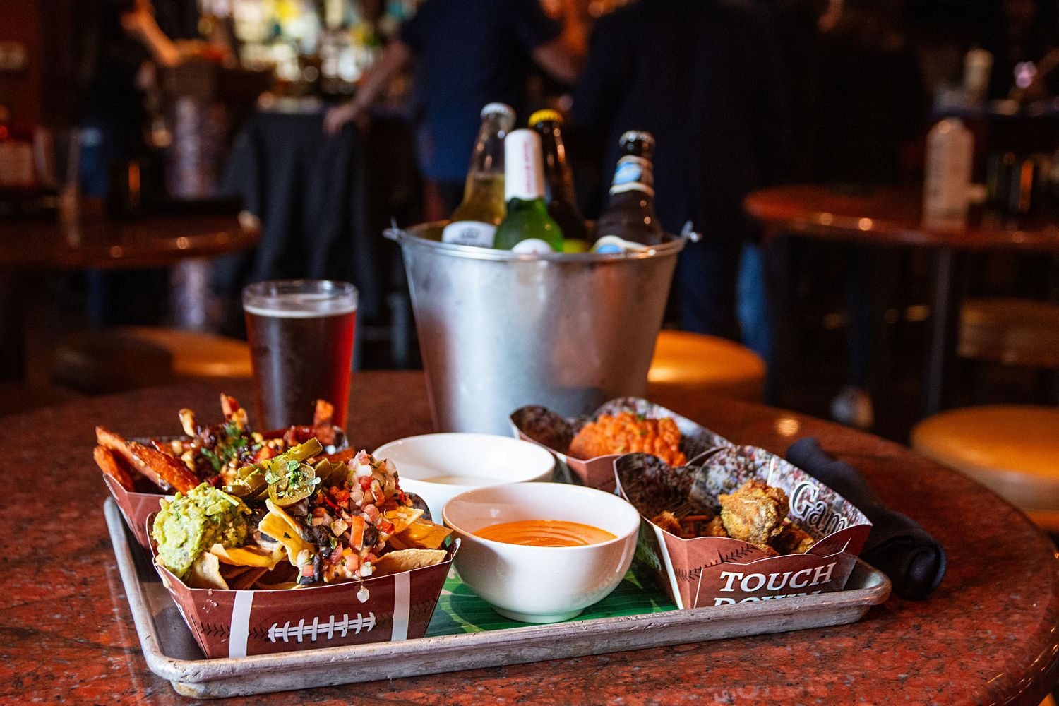 Dimly lit restaurant table with artfully plated appetizers and dipping sauces.