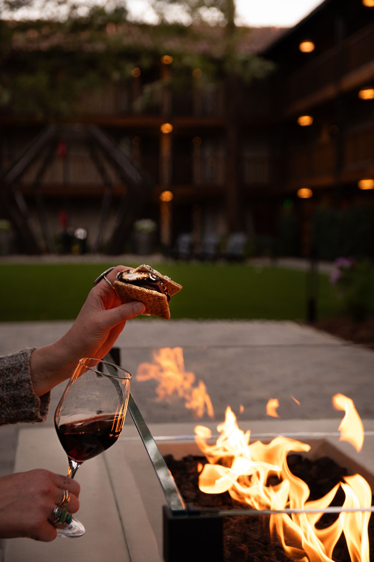 Evening gathering around an outdoor fire pit with wine glasses and warm ambiance.
