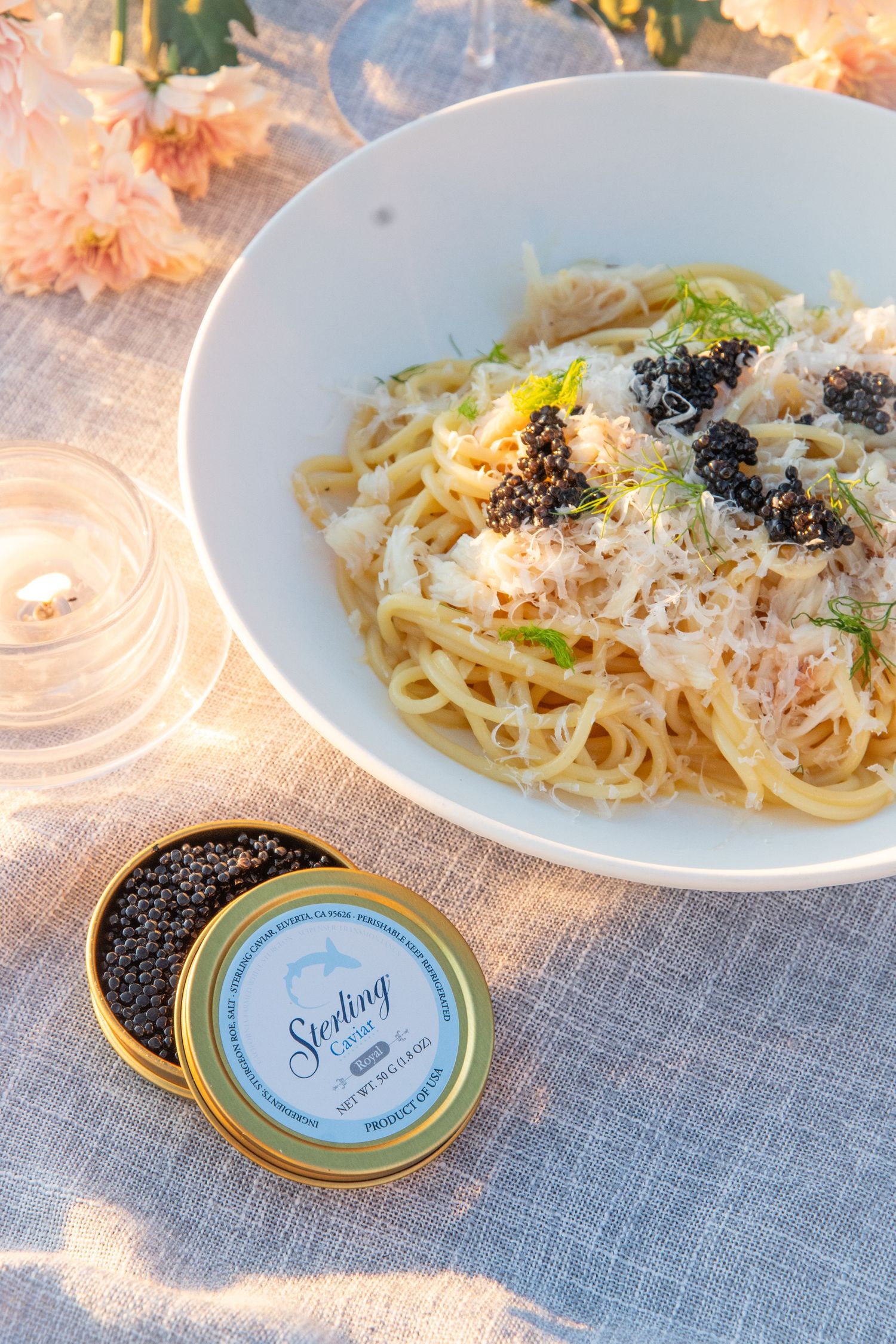 Spaghetti with parmesan and black truffles served alongside caviar tin.