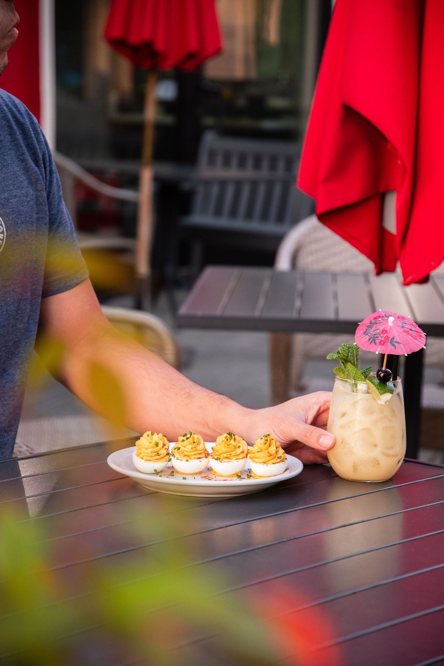 Appetizers and tropical drinks arranged on an outdoor patio table.