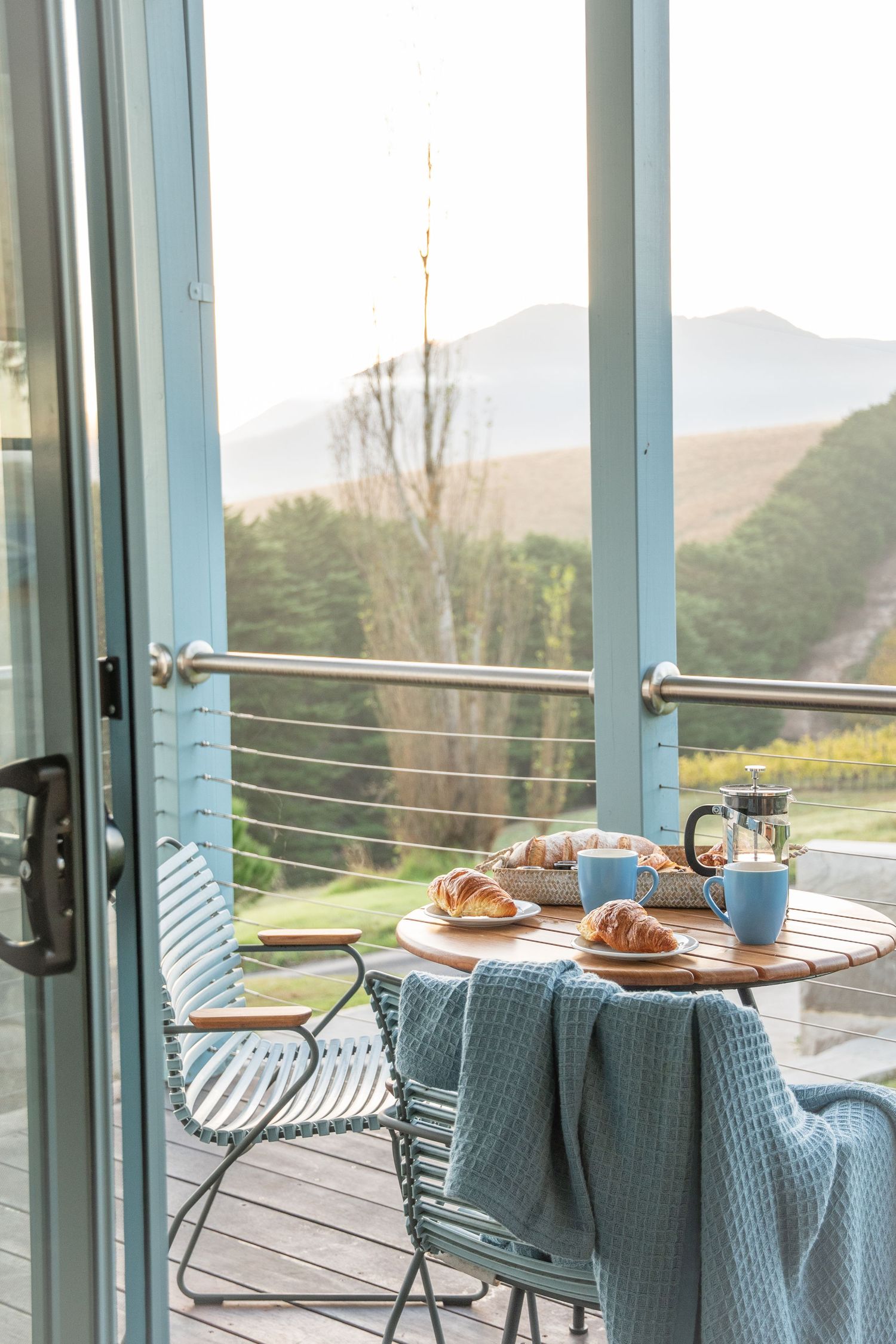 Outdoor dining terrace with modern furniture overlooking mountain views.
