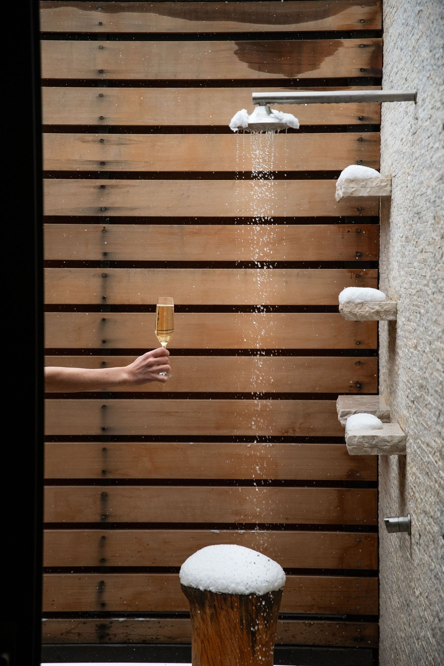 Snow falling from wooden slats creating a serene winter scene.