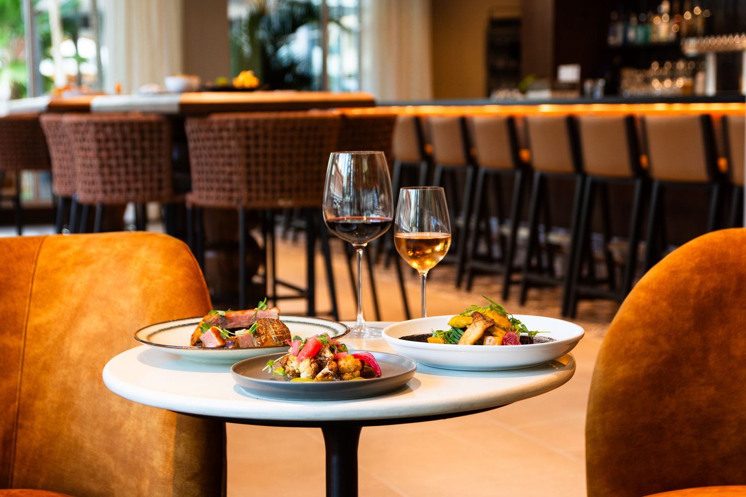 Elegant table setting with wine glasses and plated dishes in a modern restaurant interior.