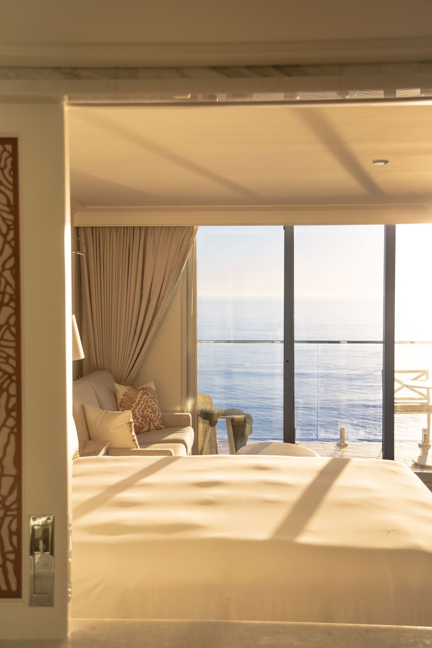 Luxurious oceanfront hotel room with white bedding and panoramic sea views.