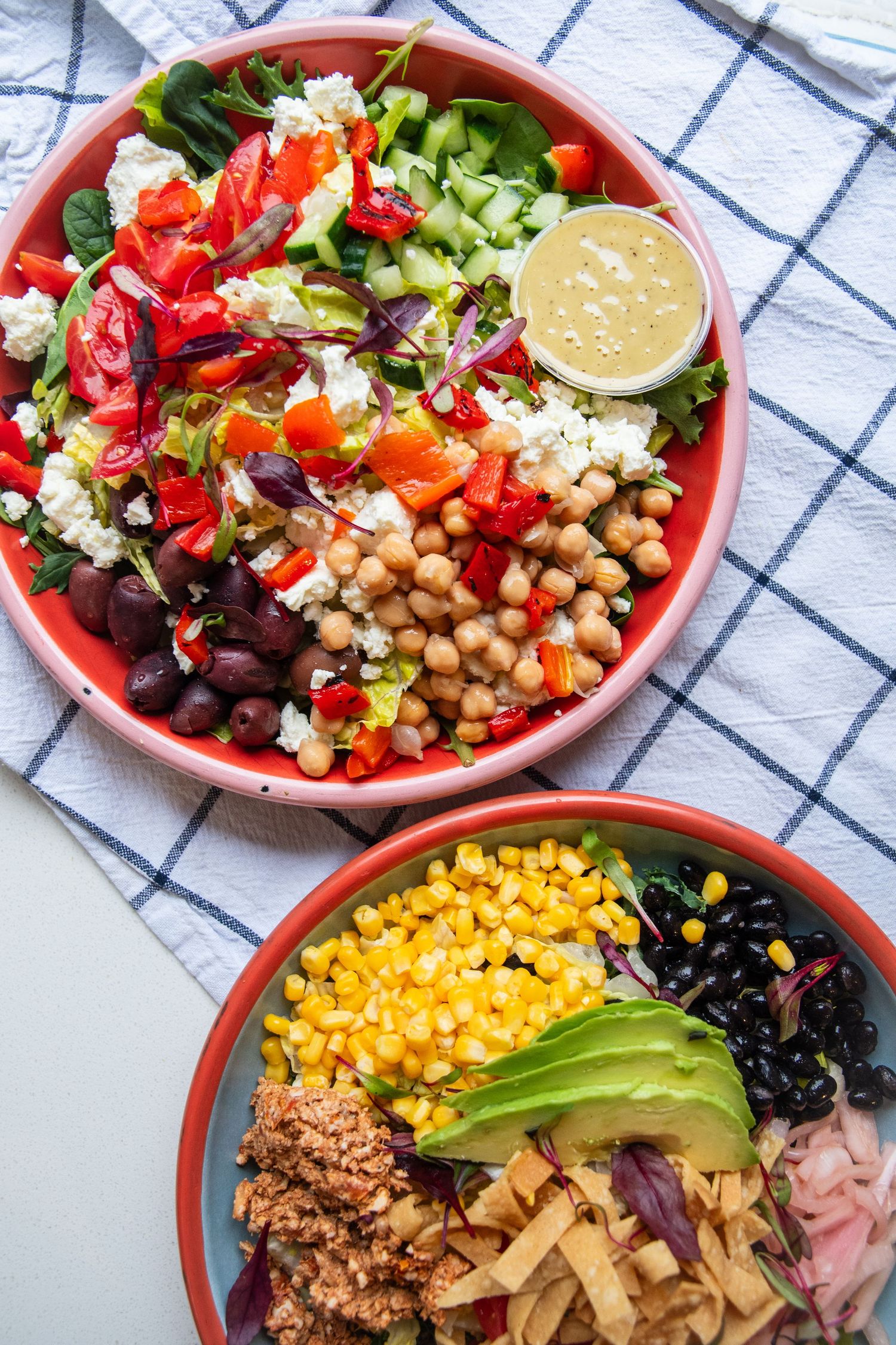 Colorful bowl filled with chickpeas, corn, avocado and fresh vegetables in a vibrant salad arrangement.