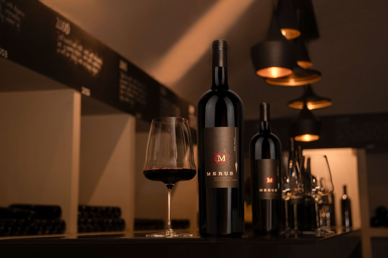 Moody interior of a wine bar with bottles displayed on shelves.