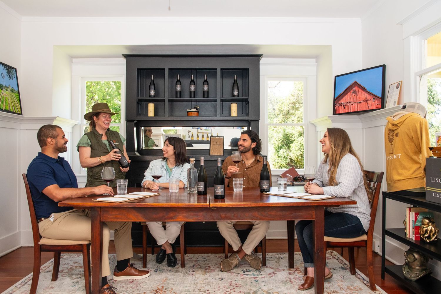Interior of a wine tasting room with people seated at tables.