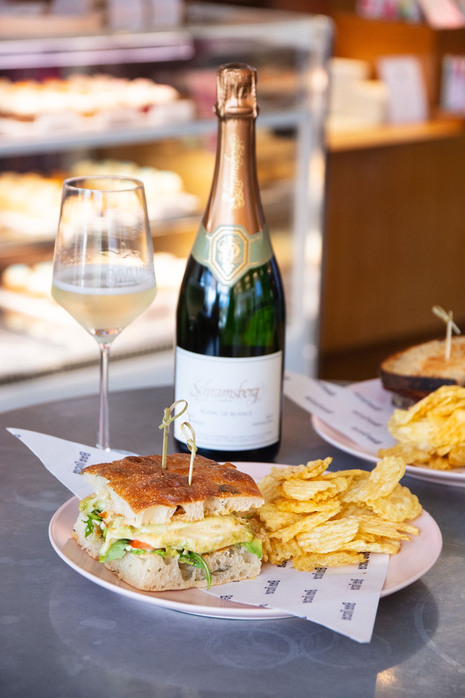 Sandwich plate served with potato chips and champagne at upscale restaurant.