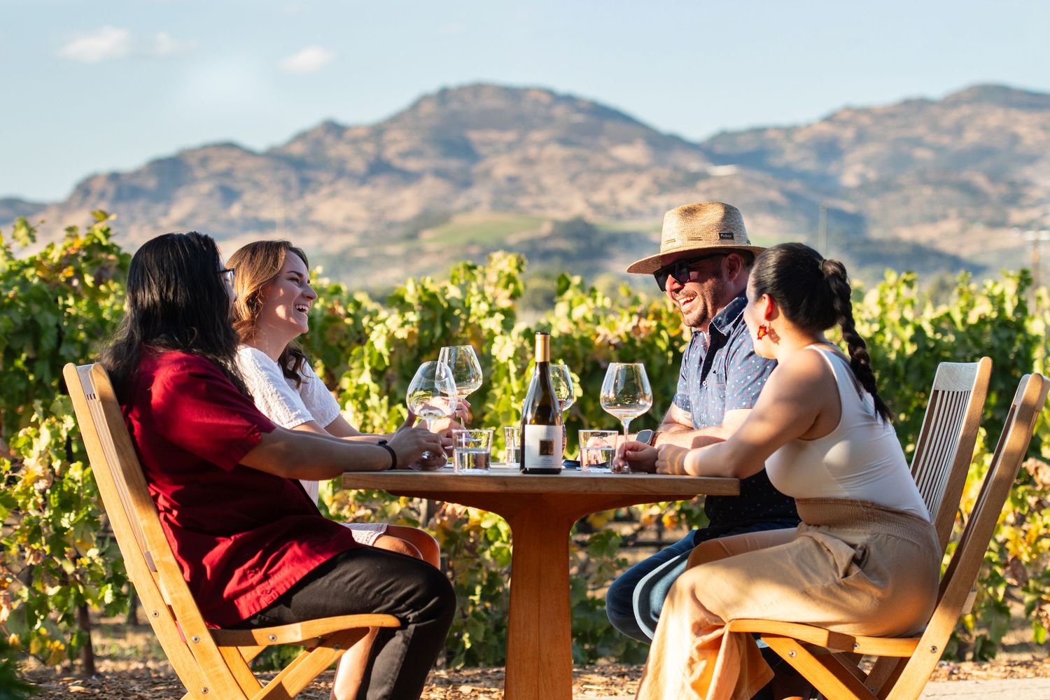 Scenic vineyard seating area with mountain views and outdoor tables for wine tasting.