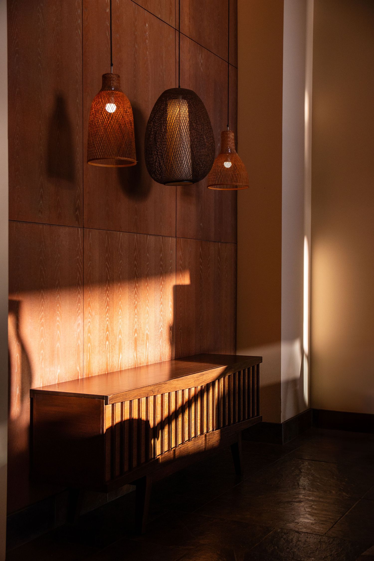 Dimly lit hallway with wooden walls and hanging pendant lights creating a warm, atmospheric ambiance.