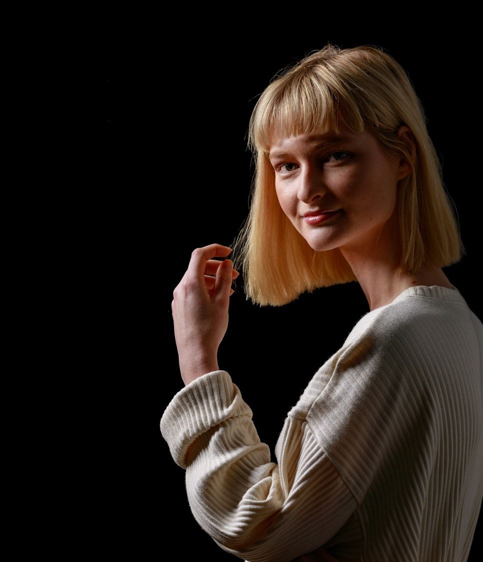 Minimalist portrait series in cream sweater with dramatic side lighting.