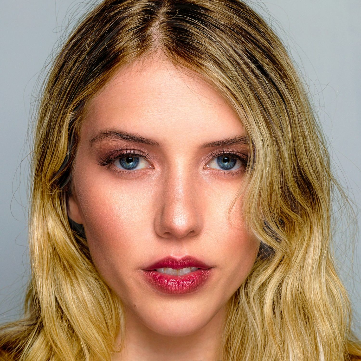Close-up beauty portraits with bright red lips and blonde hair against light background.