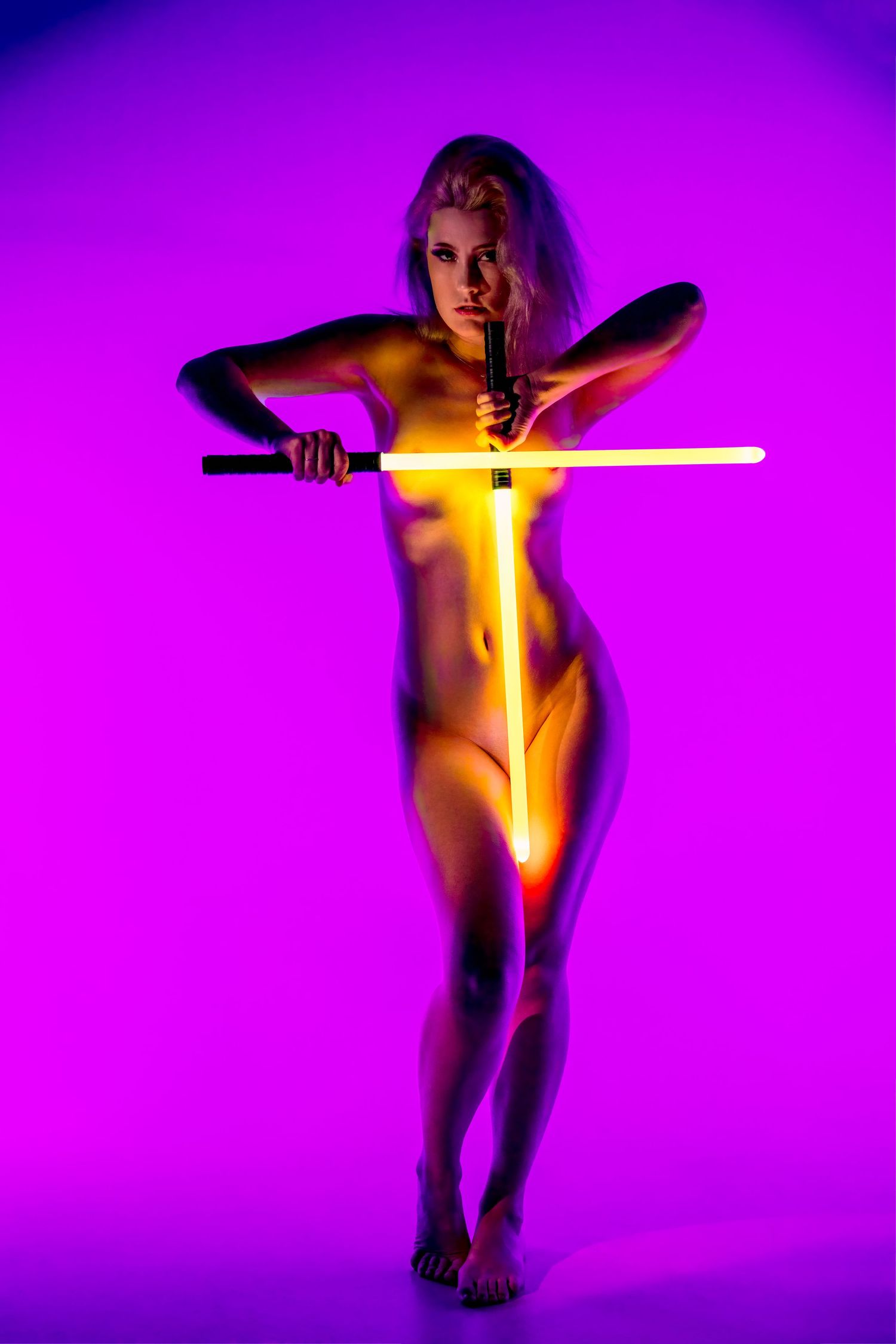 Silhouetted figure holding glowing yellow lightsaber against vibrant purple background in artistic photo sequence.