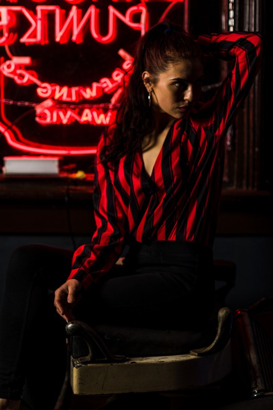 Atmospheric portraits with red neon lighting in dark setting.
