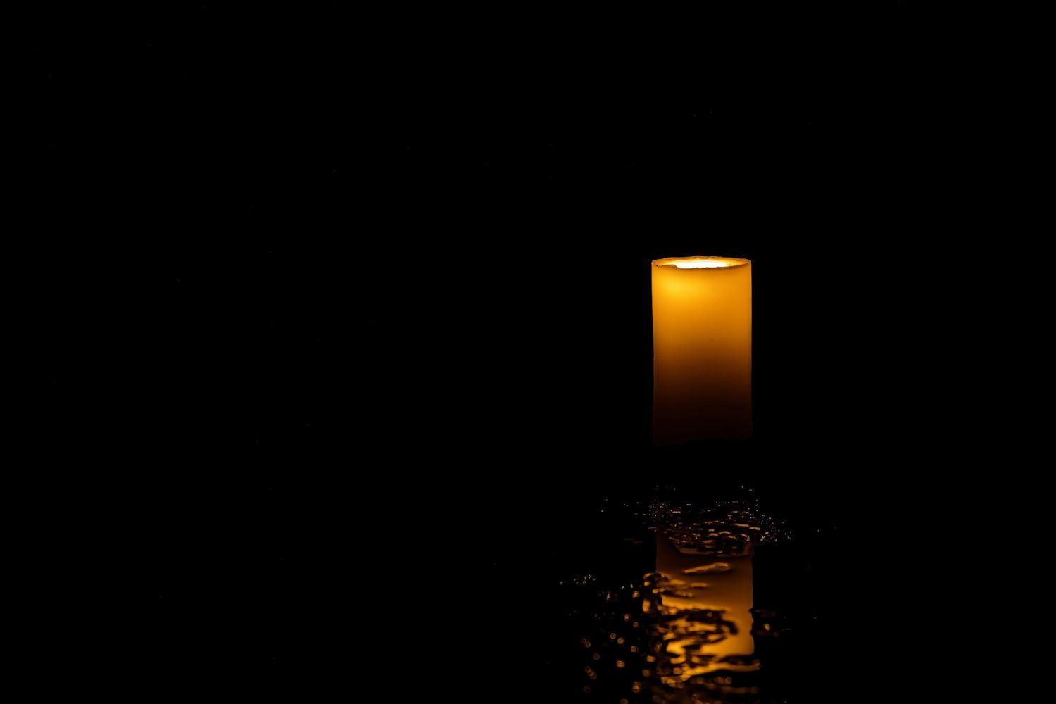 Glowing orange sunset reflected in calm ocean waters.
