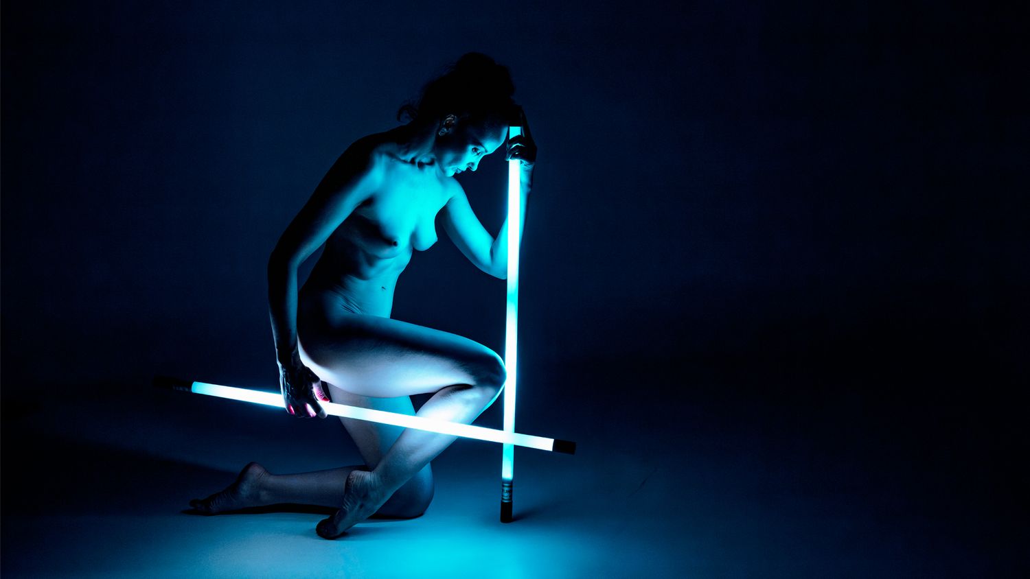A silhouetted figure performs a parkour jump sequence in dramatic blue lighting against a dark background.