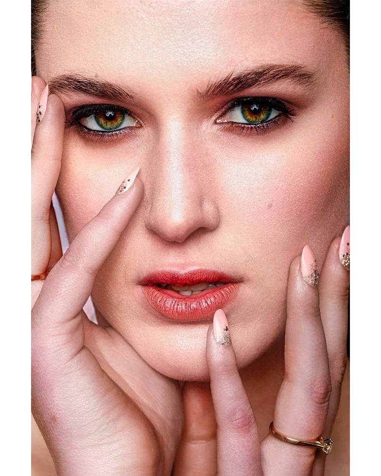 Close-up beauty shot with shimmering makeup and red lips.