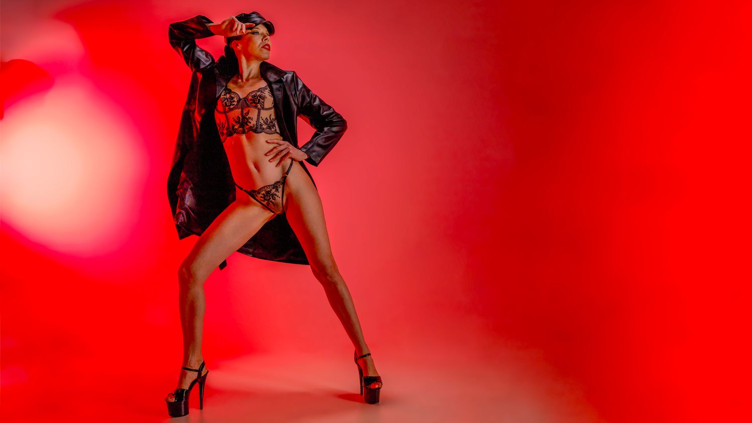 A silhouetted figure in a dramatic pose against a vibrant red background with dynamic lighting effects.