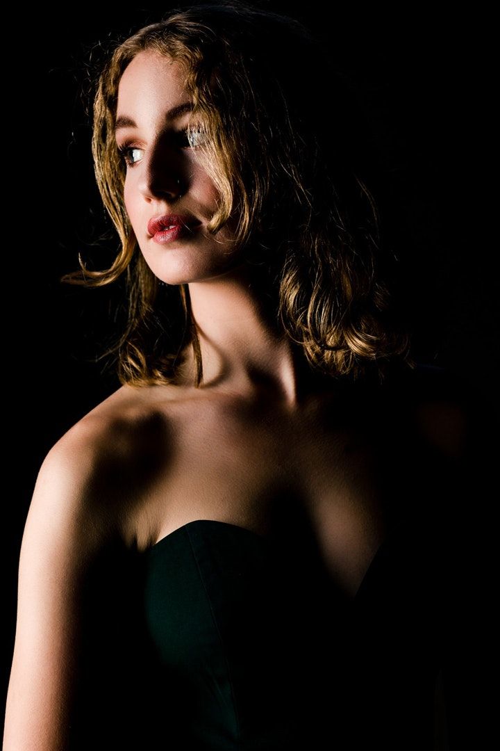 Dramatic portrait series with moody lighting and shadows against dark background.