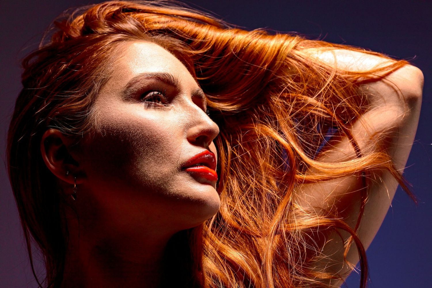 Close-up beauty shots featuring flowing copper hair against dark background.