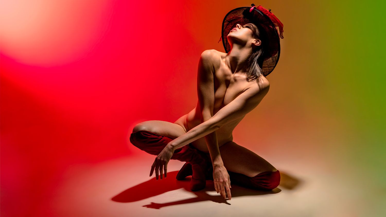 A red and green gradient background creates a vibrant abstract design with soft bokeh lighting effects.