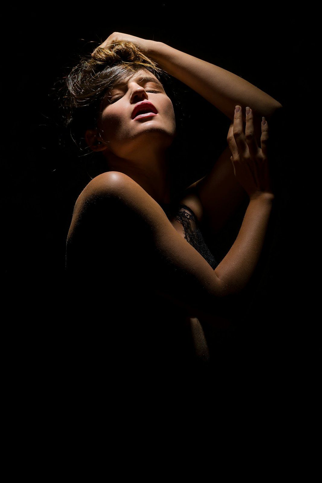 Artistic boudoir silhouette with dramatic shadows and lighting.