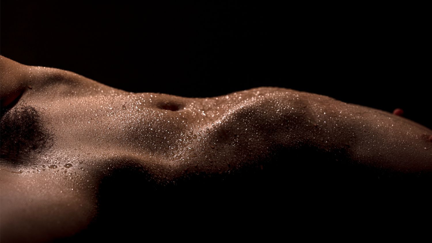 Abstract artistic composition of dark brown curved shapes against black background creating a sensual aesthetic.