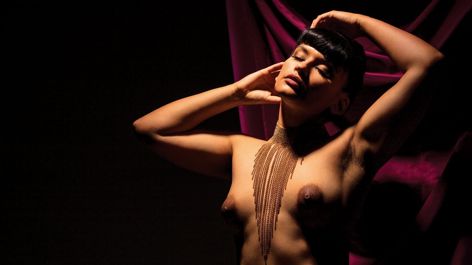 Dramatic boudoir photography series with artistic poses against dark burgundy backdrop.