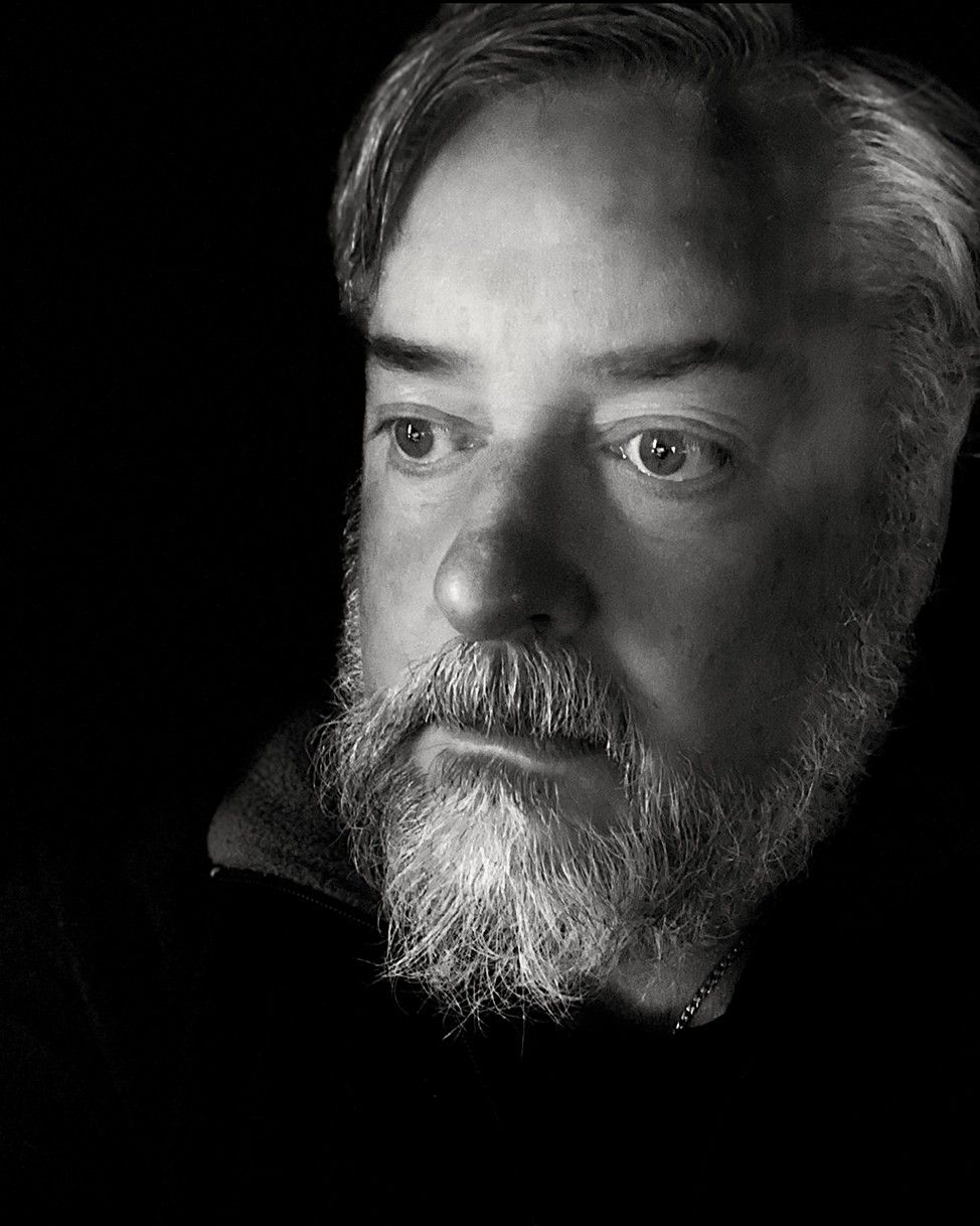 Black and white portraits showing different angles of a bearded man.