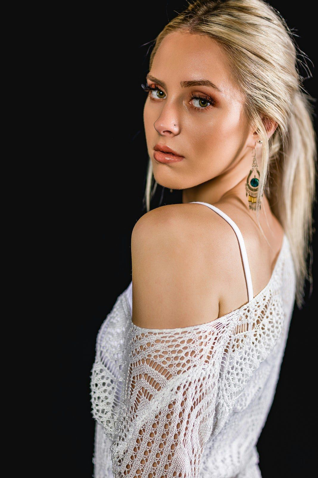 Elegant portraits in white lace against dark background with subtle lighting.