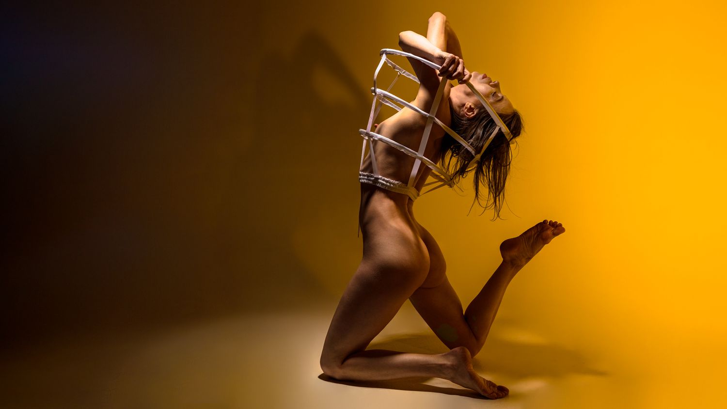 Artistic silhouette of a figure posing with chocolate dripping against a warm orange background.