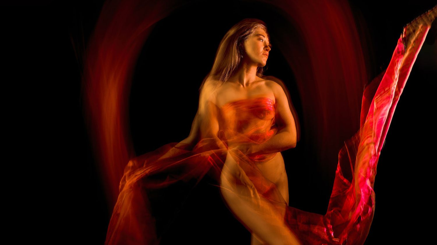 Artistic dance performance silhouettes in red and orange lighting create a dramatic visual effect on stage.